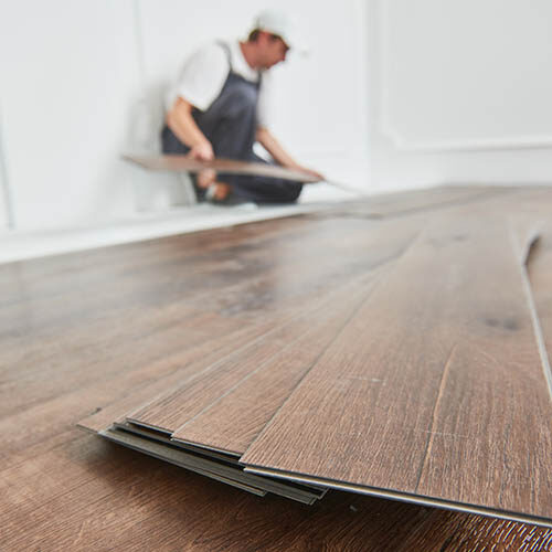 Worker laying vinyl floor covering | Color Interiors